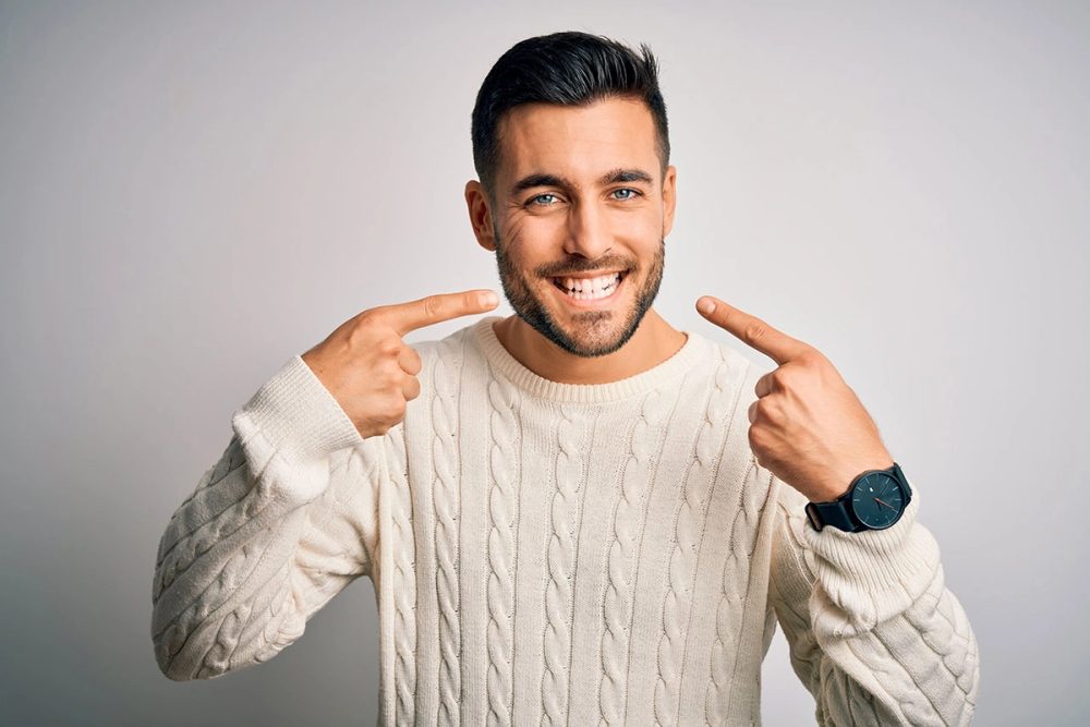 Smiling man pointing to his teeth